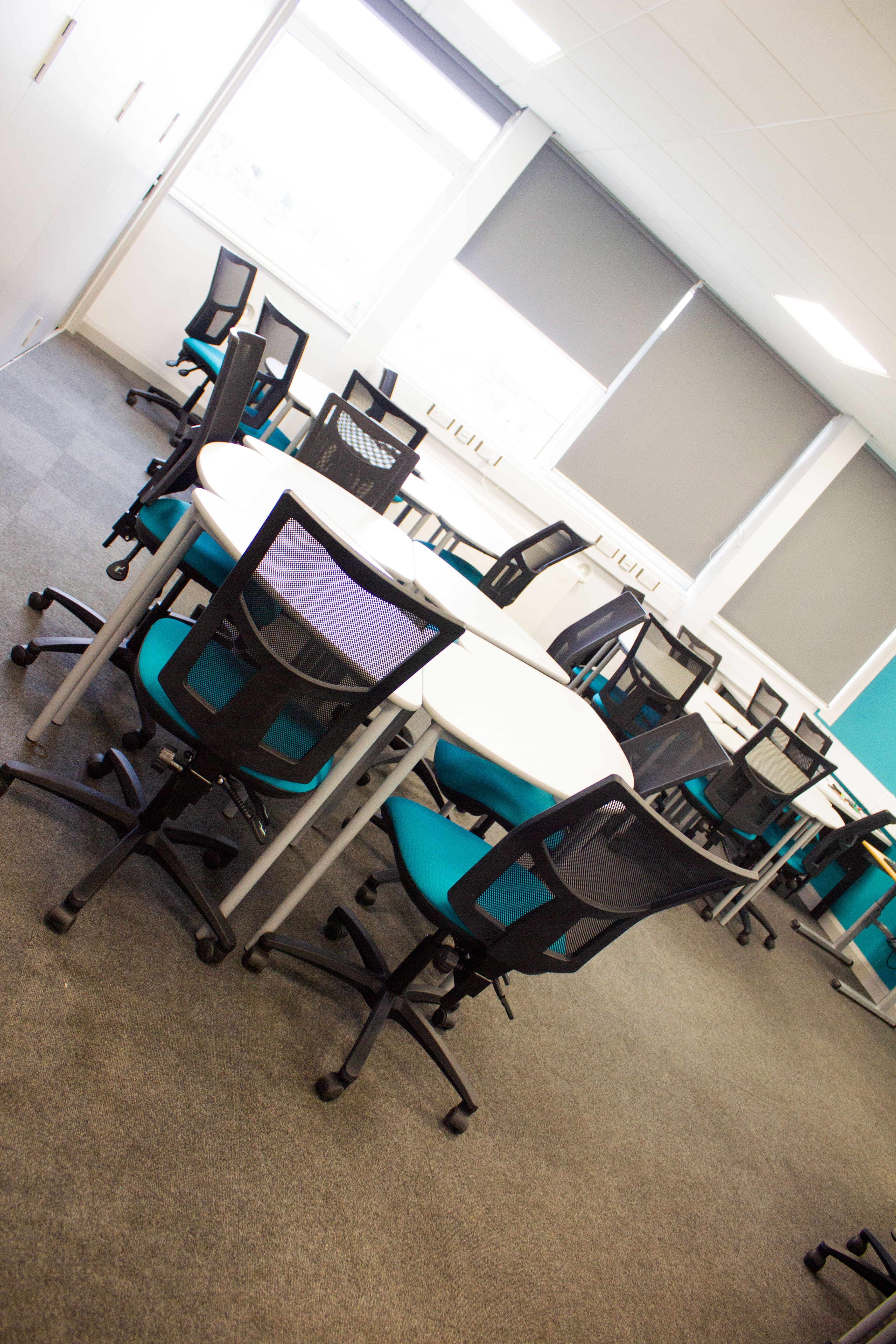 business classroom with circle tables with chairs around 