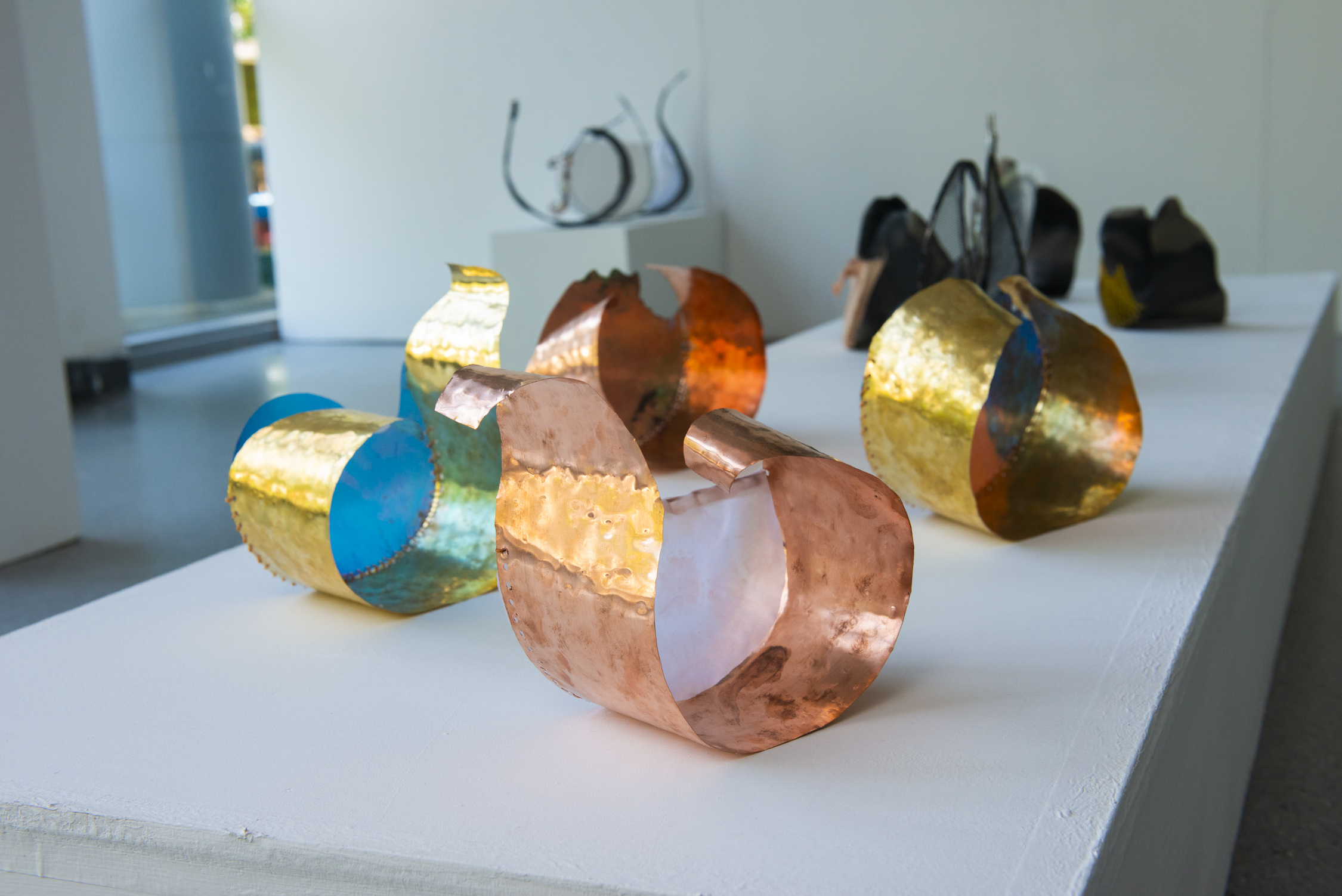 a group of different coloured mental ring sculptures sitting on top of a white table