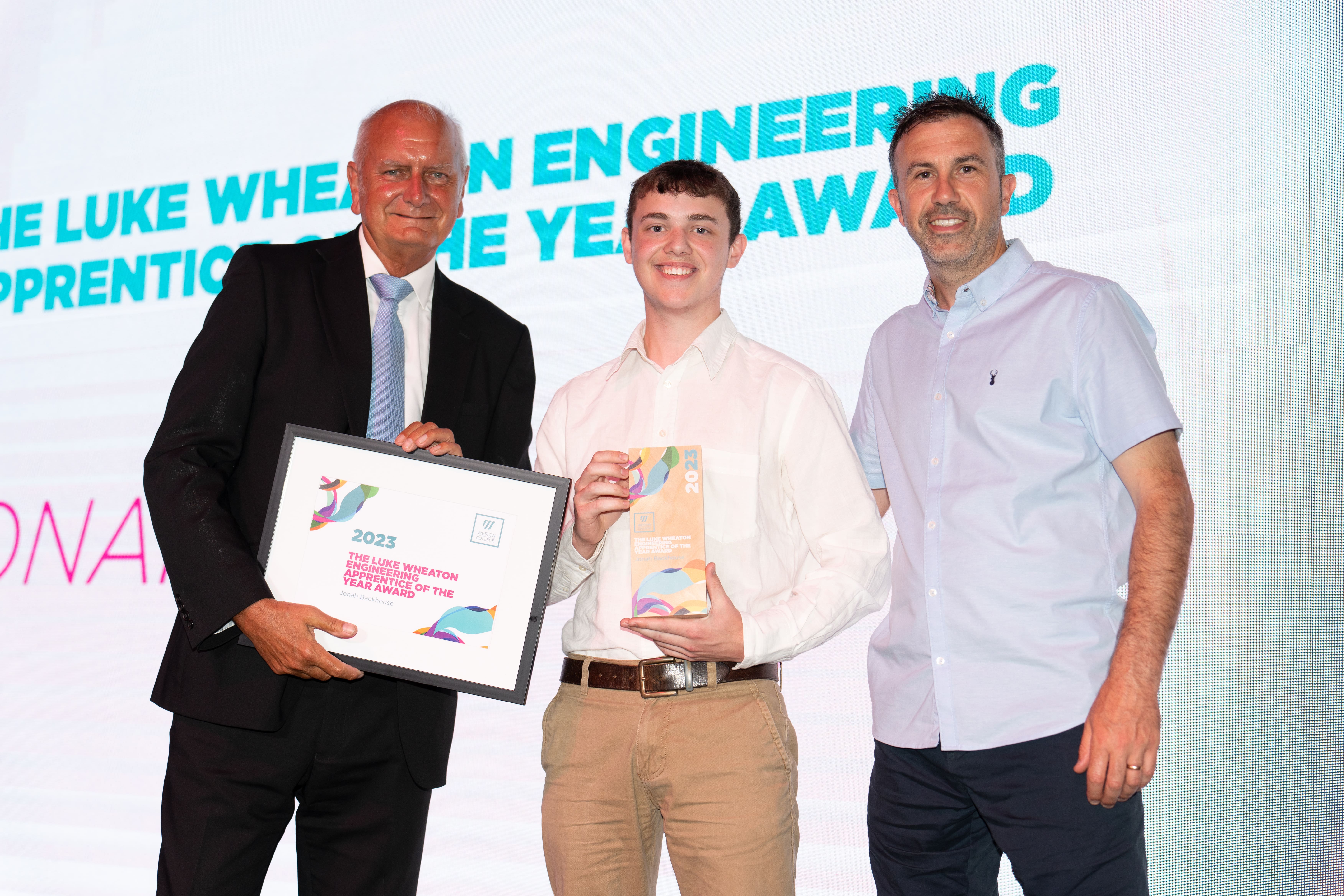 Jonah, on stage holding thier award next to Andy Lewis