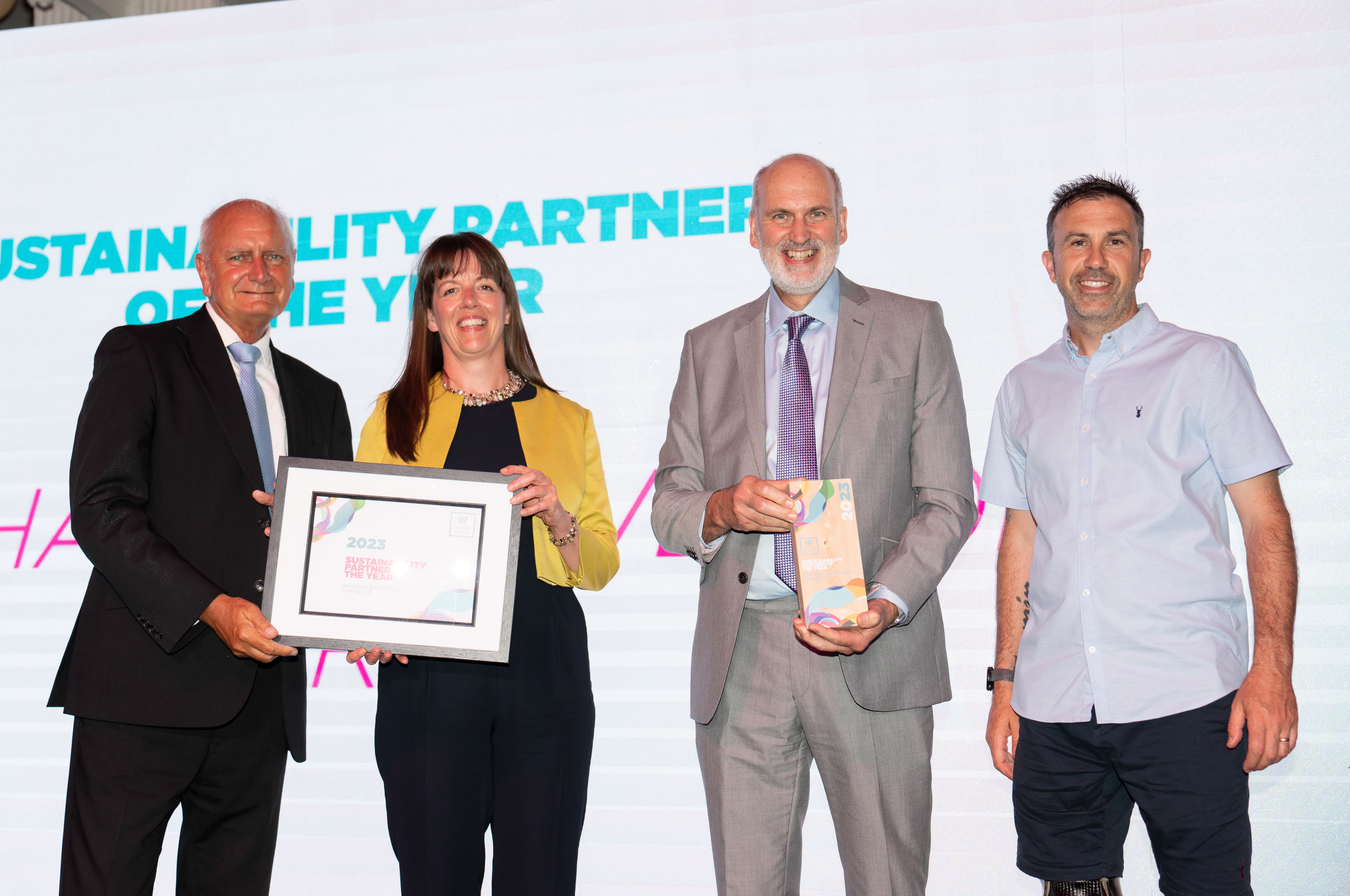 Burnham and Weston Energy, on stage holding thier award next to Andy Lewis