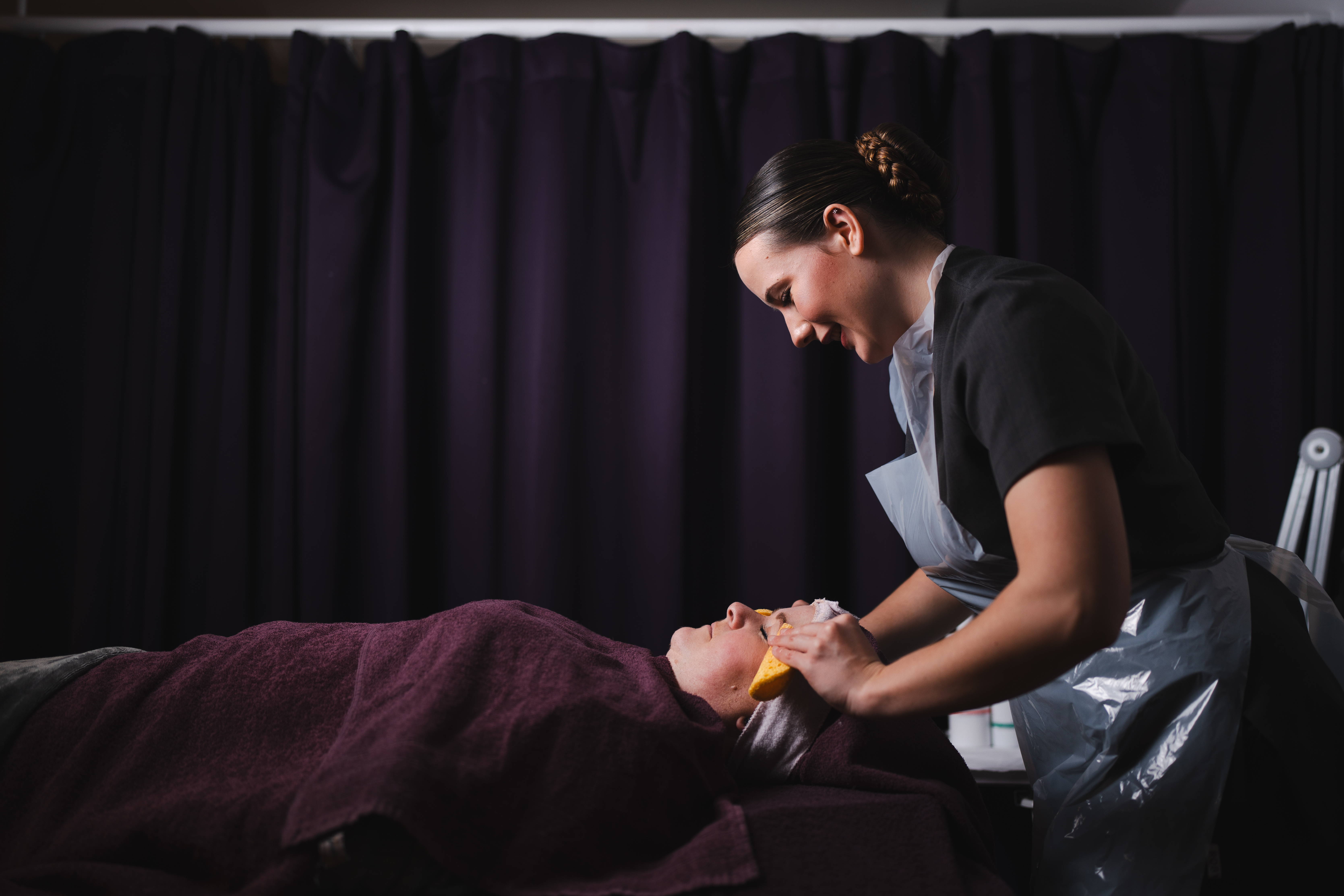 beauty therapy student giving client facial