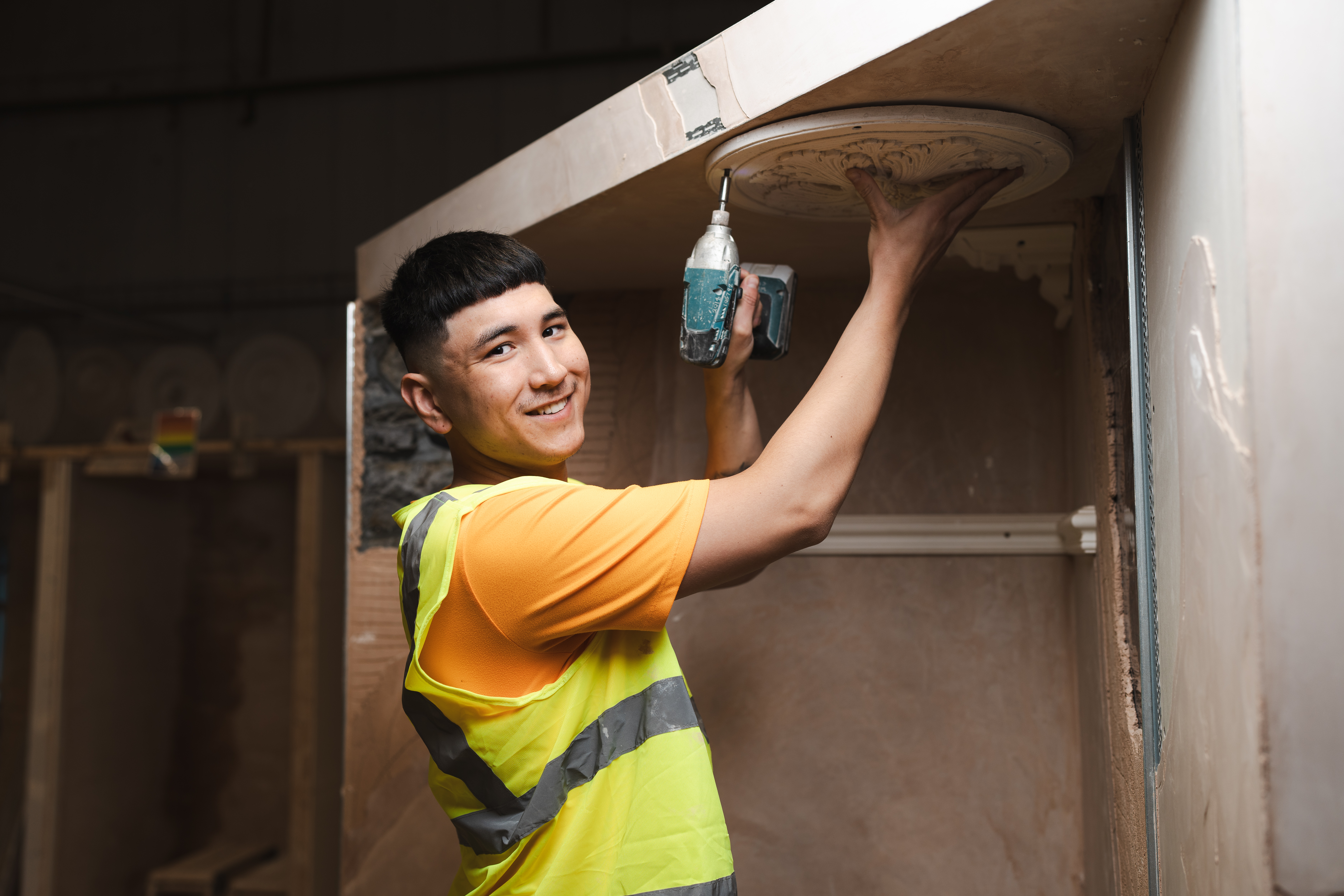 plastering student drilling wall