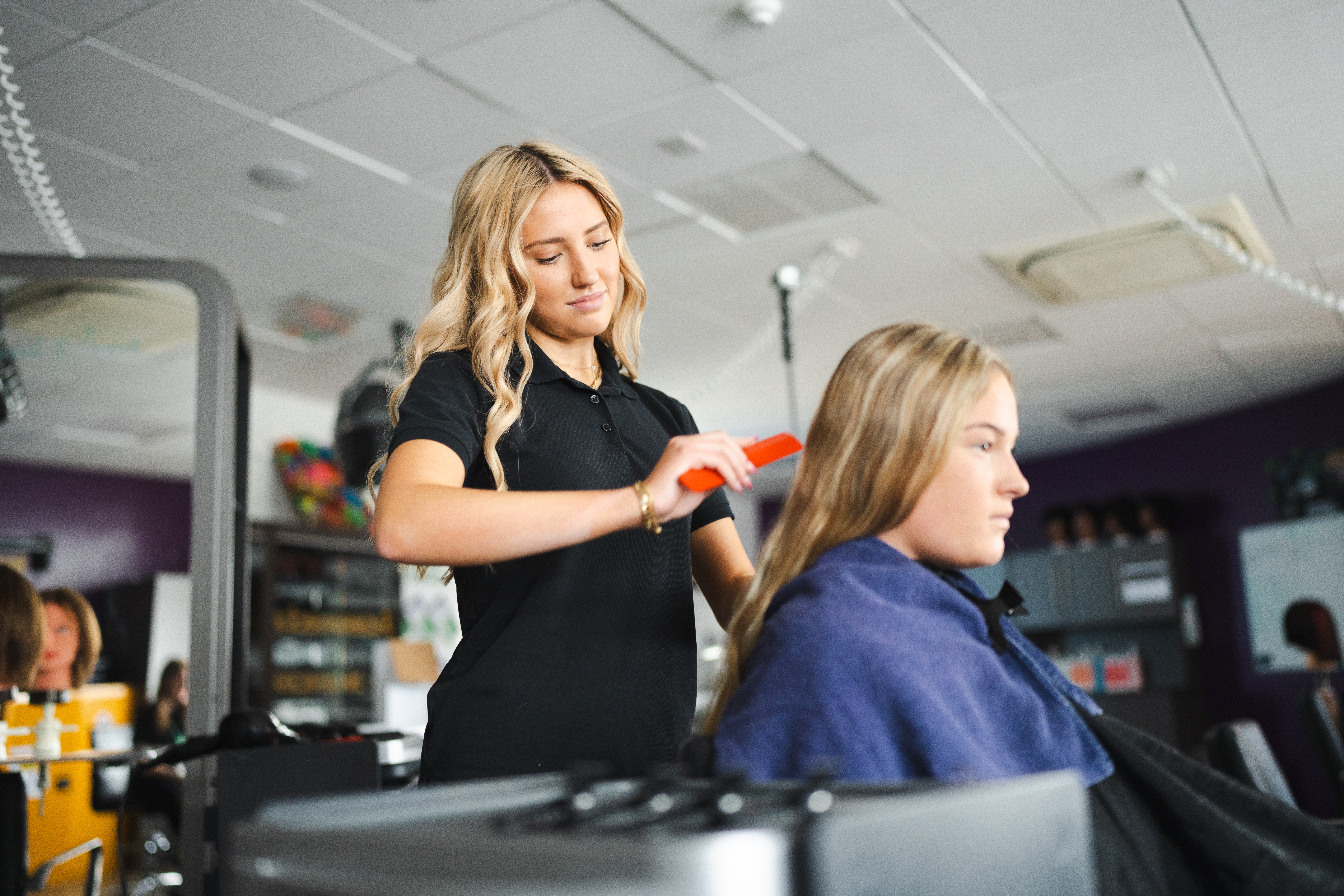 hair and beauty student combing client's hair