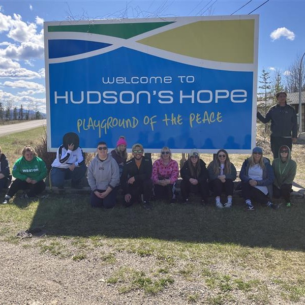 Students sat in front of the Hudson's Hope sign