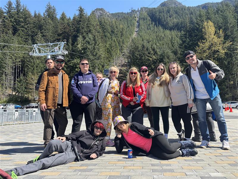 Students and staff standing in front of a mountain