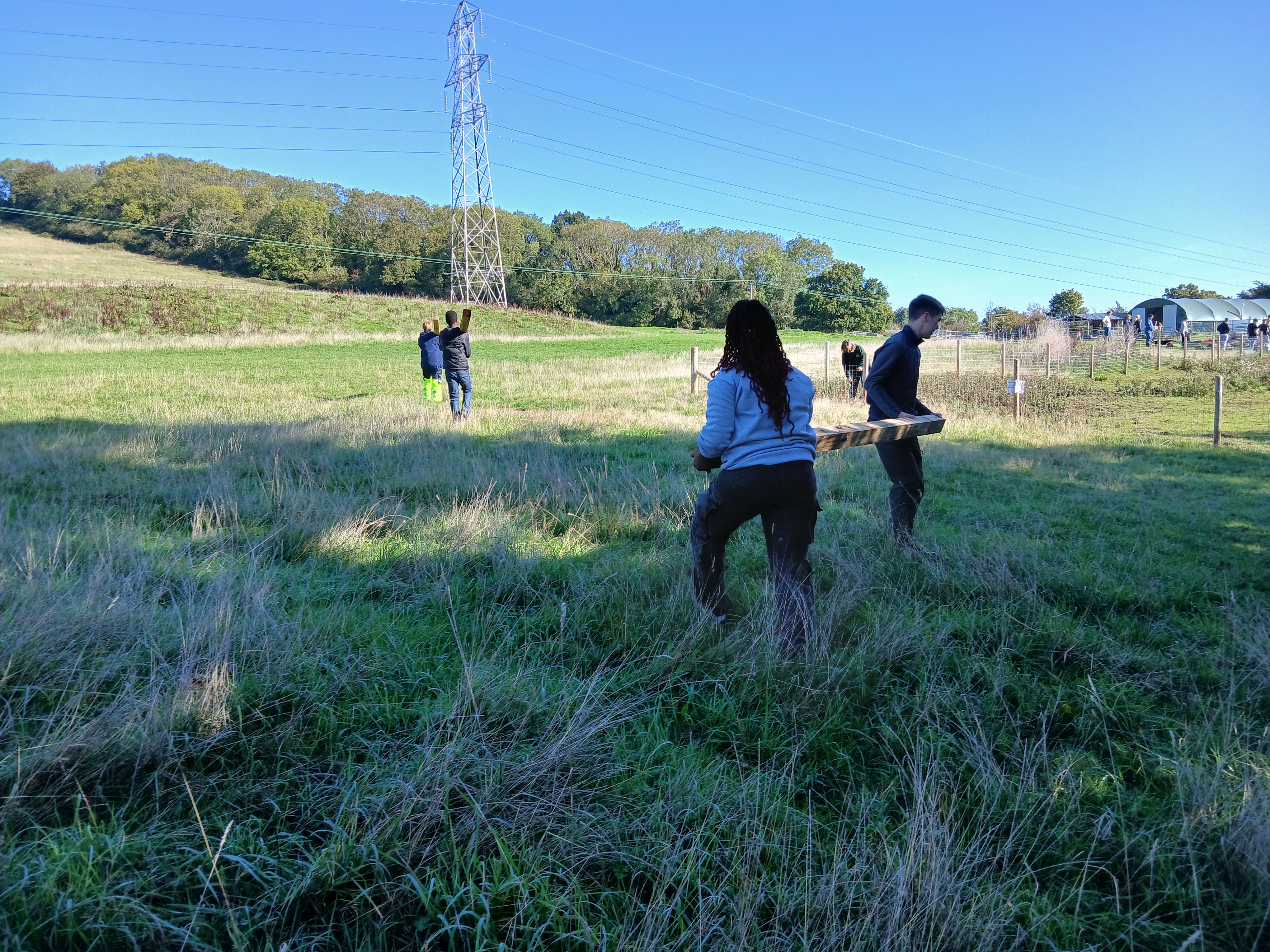 Students carrying wooden post