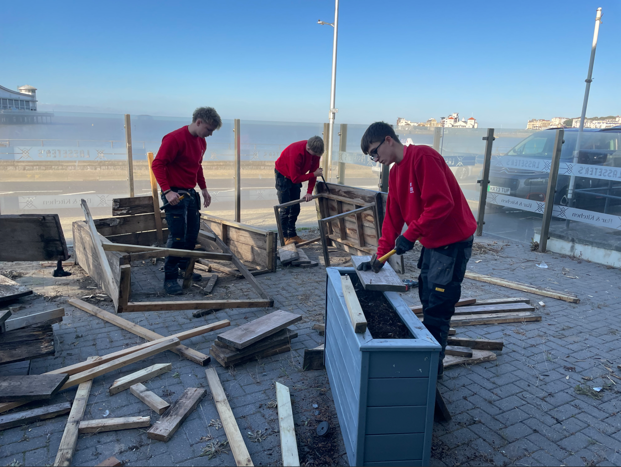 Students disassembling wooden benches
