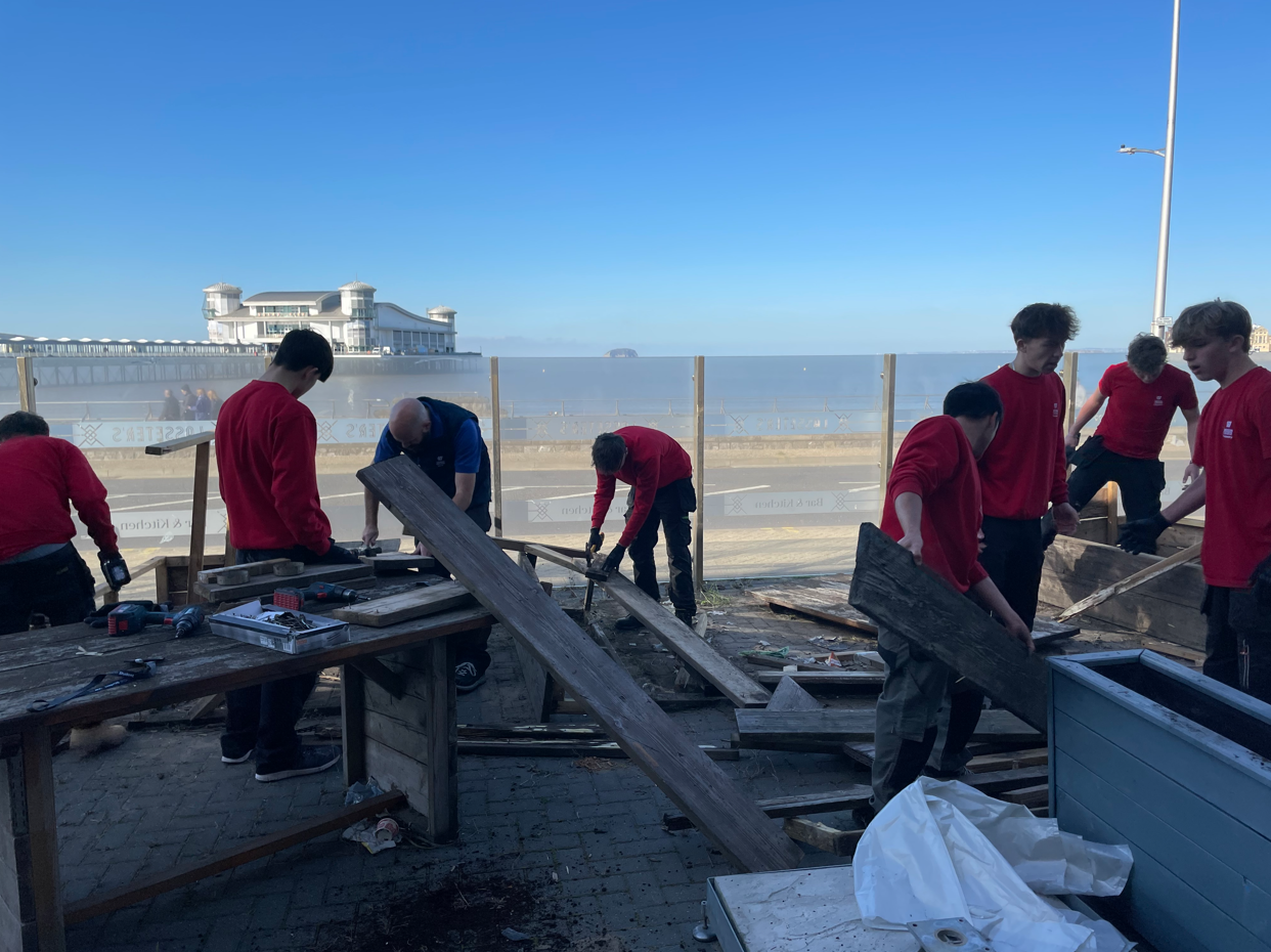 Students disassembling wooden benches