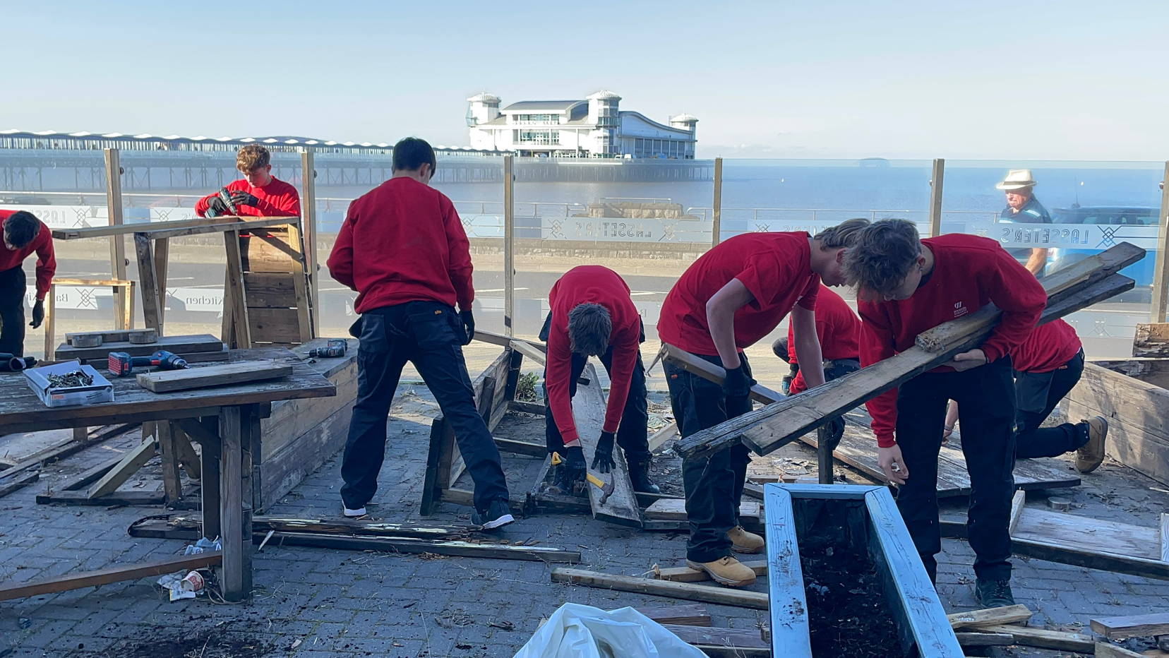 Students disassembling wooden benches