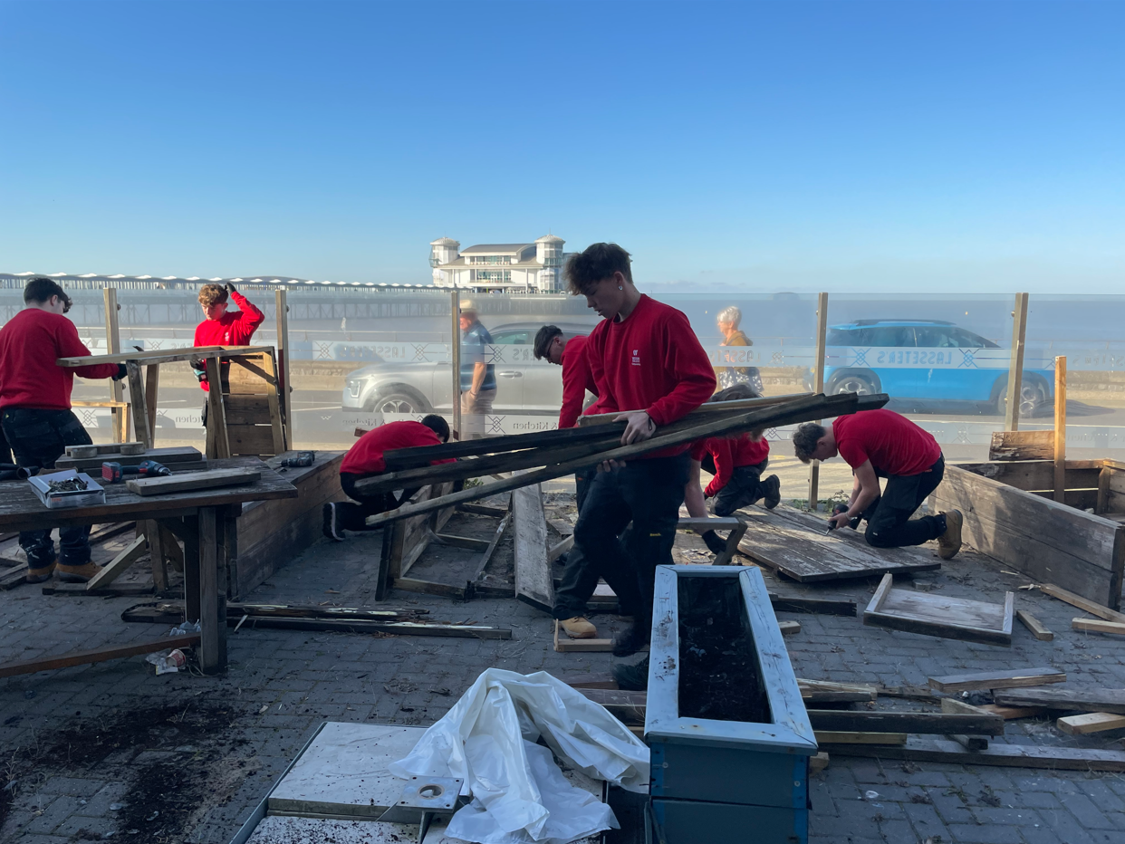 Students disassembling wooden benches