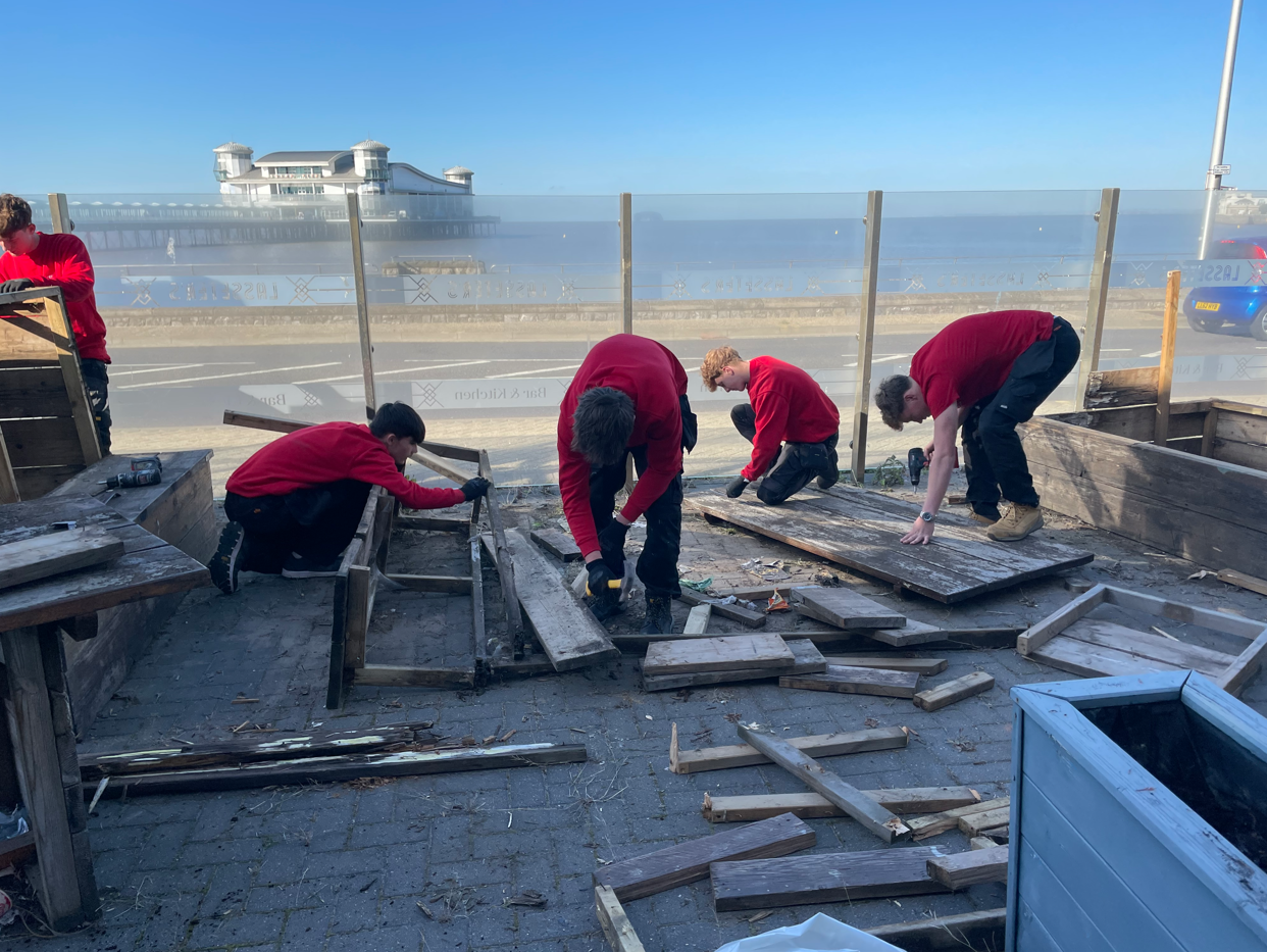 Students disassembling wooden benches