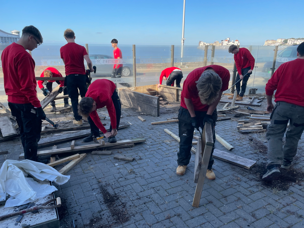 Students disassembling wooden benches