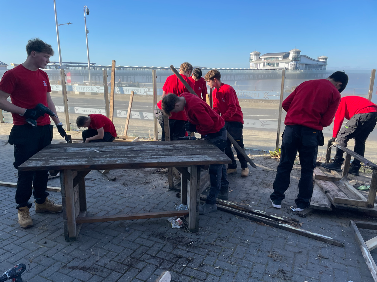 Students disassembling wooden benches