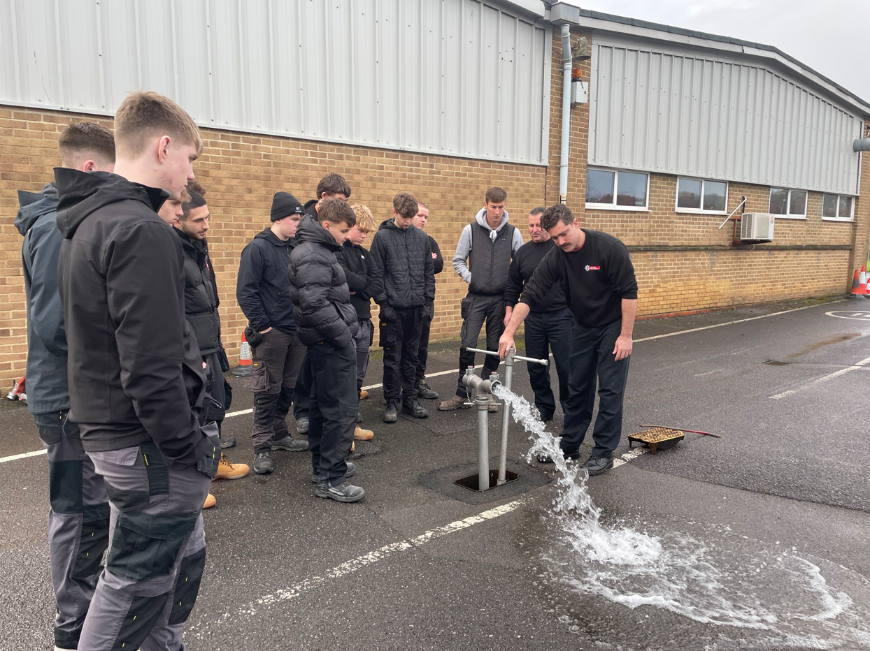 firefighter tapping into fire hydrant water