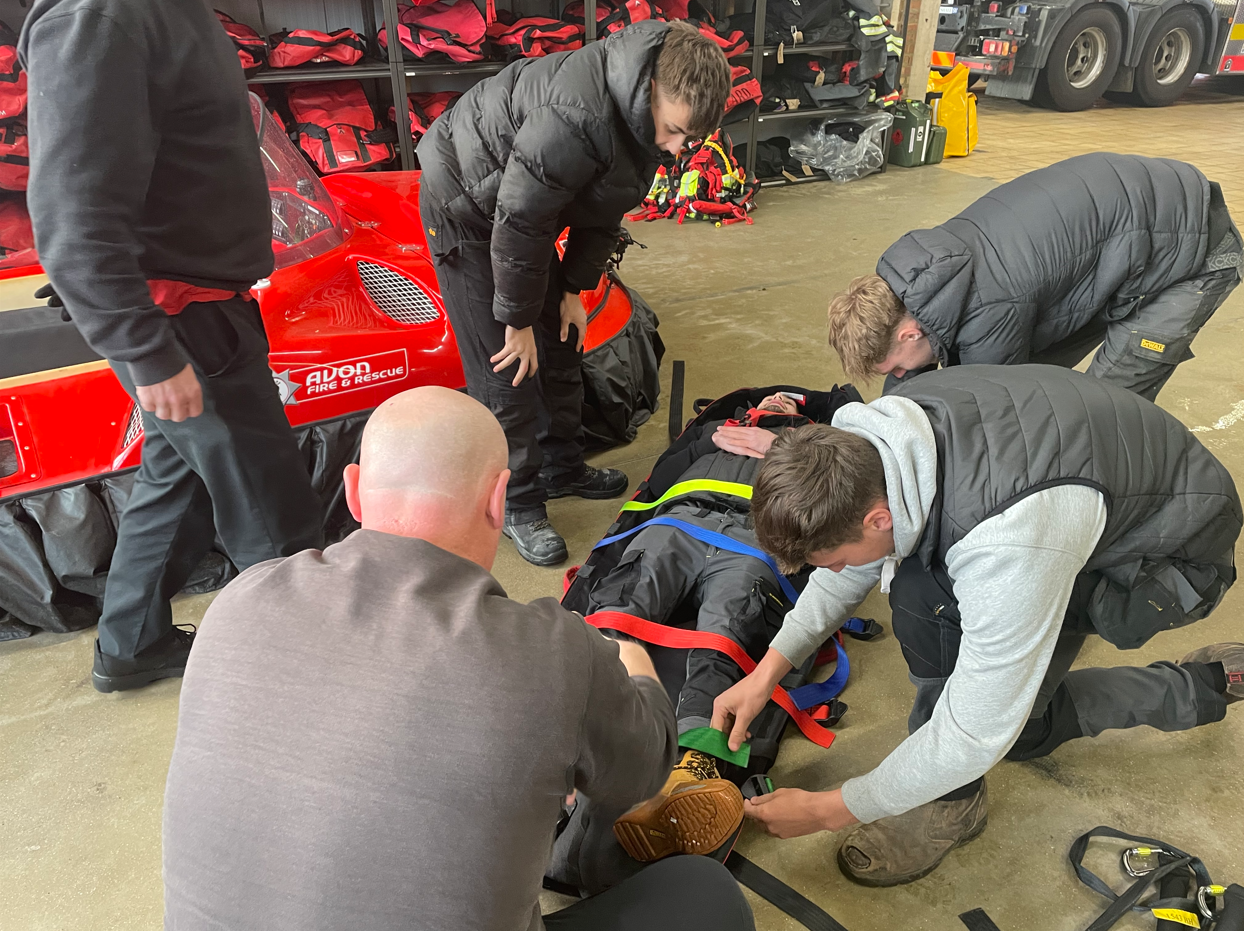 students strapping in another student onto a stretcher