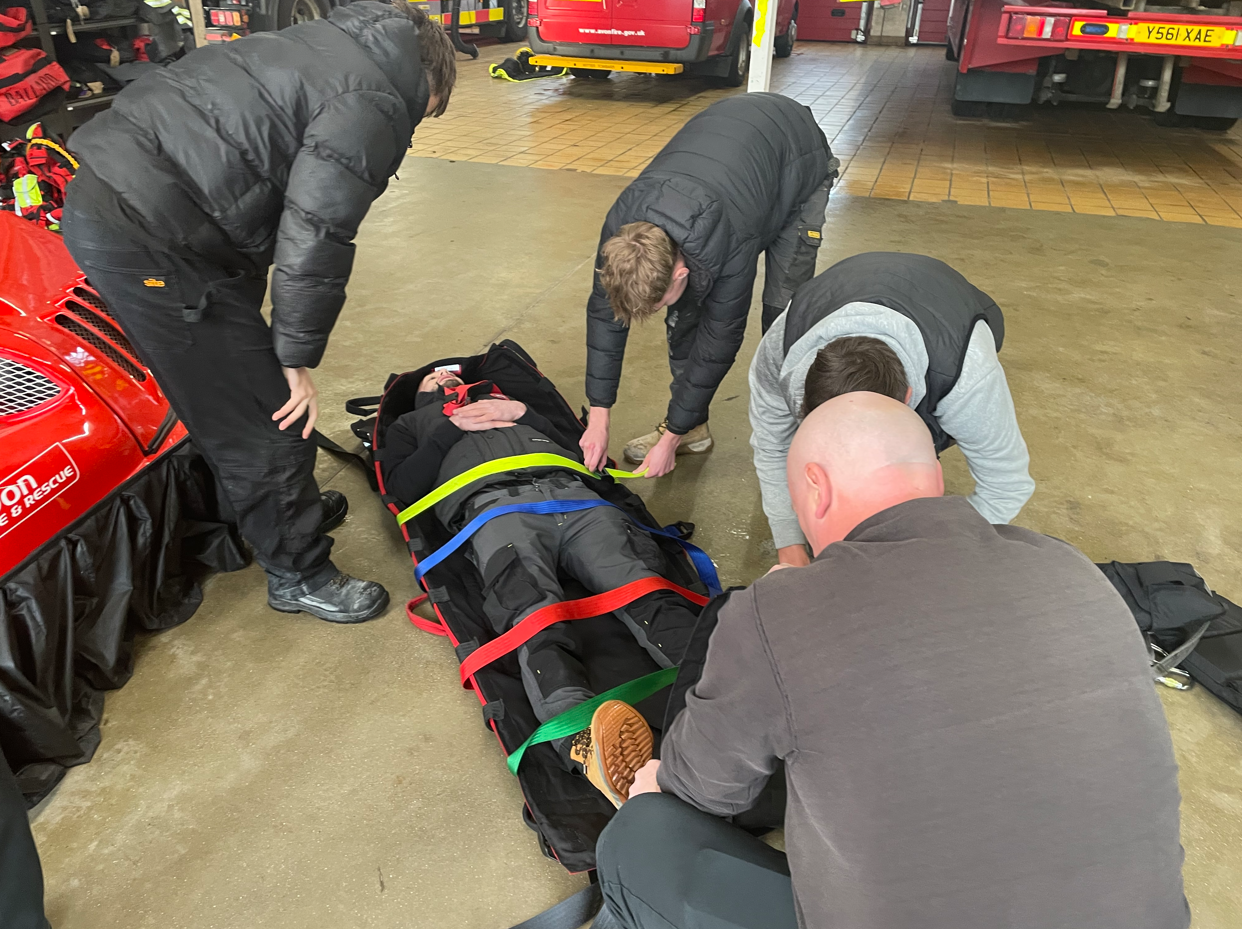students strapping in another student onto a stretcher