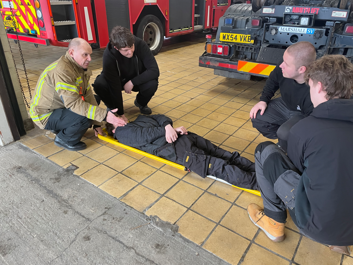 students being picked up on a stretcher