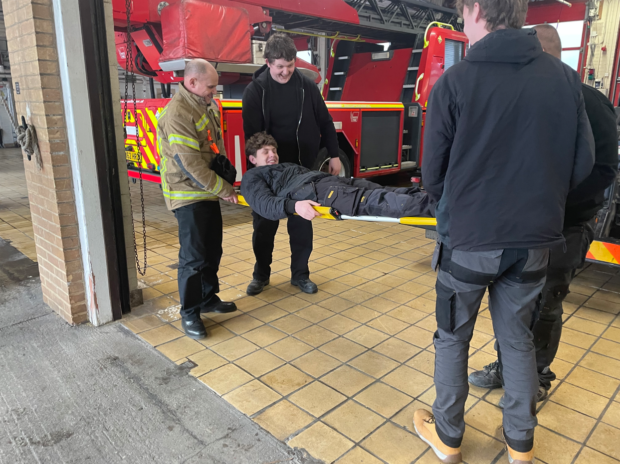 students being picked up on a stretcher