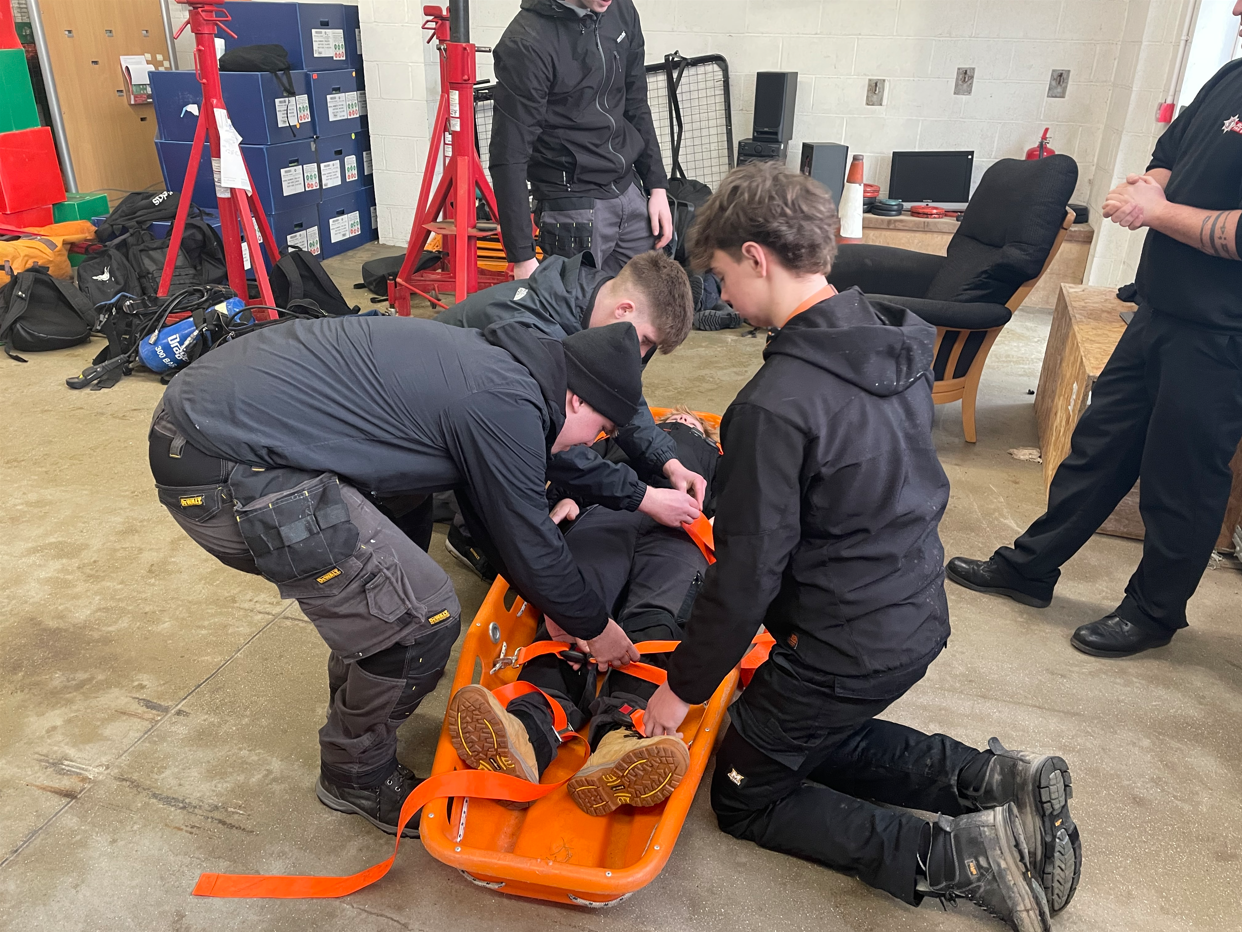 students strapping in another student onto a stretcher