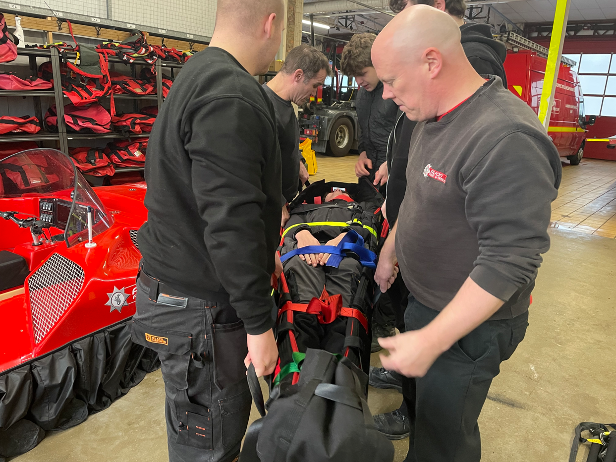 students being picked up on a stretcher