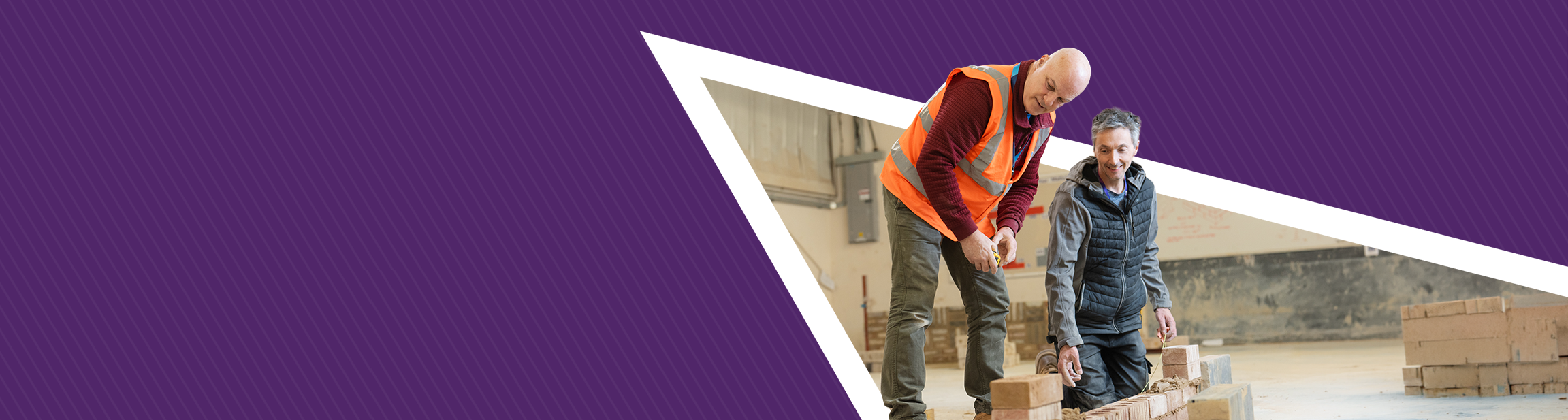 2 men lay a brick wall