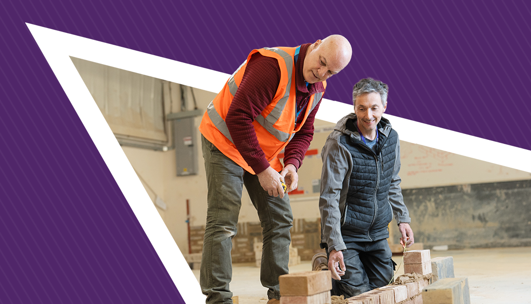 2 men lay a brick wall