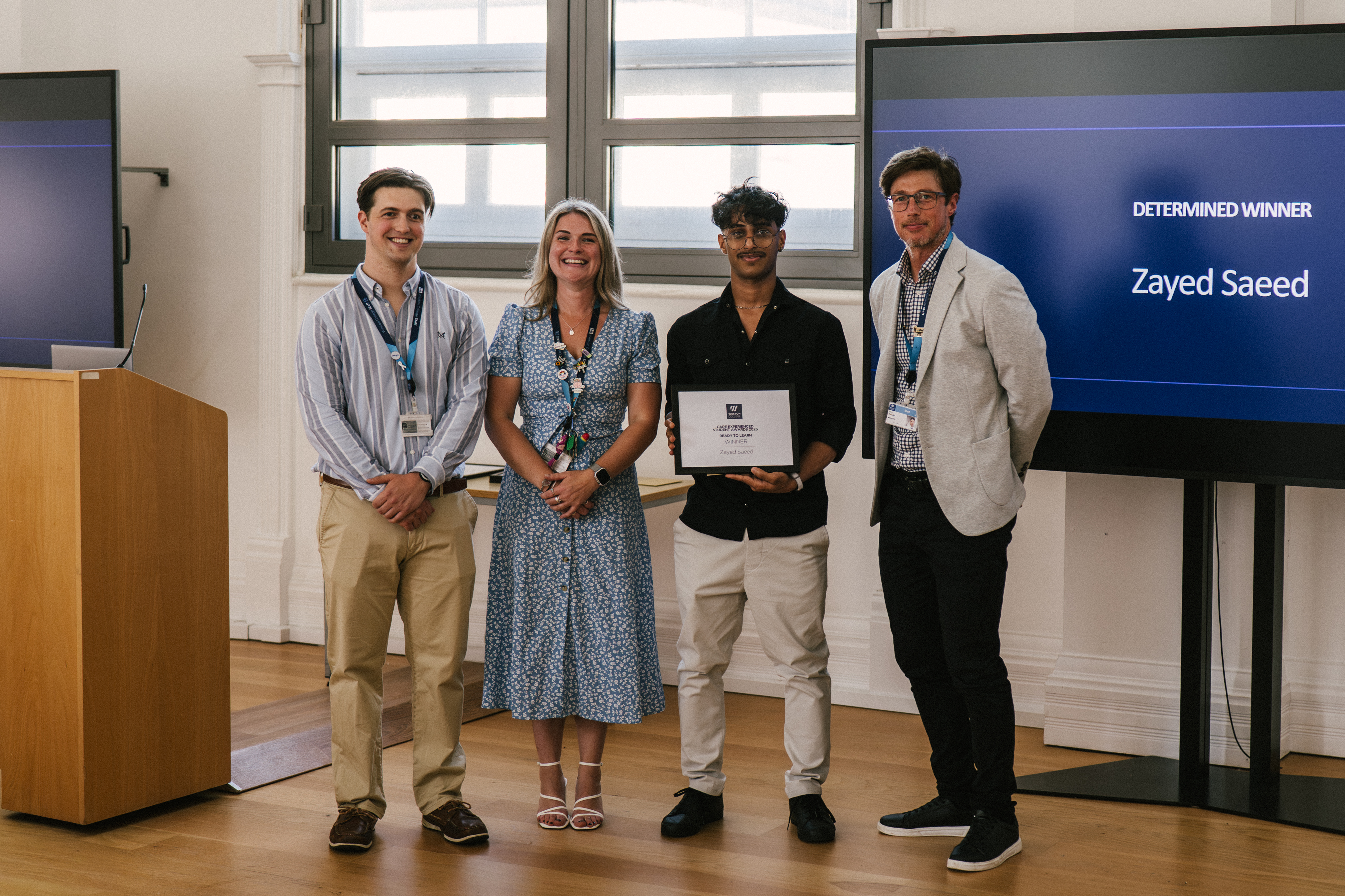 Student Holding Certificate with Staff