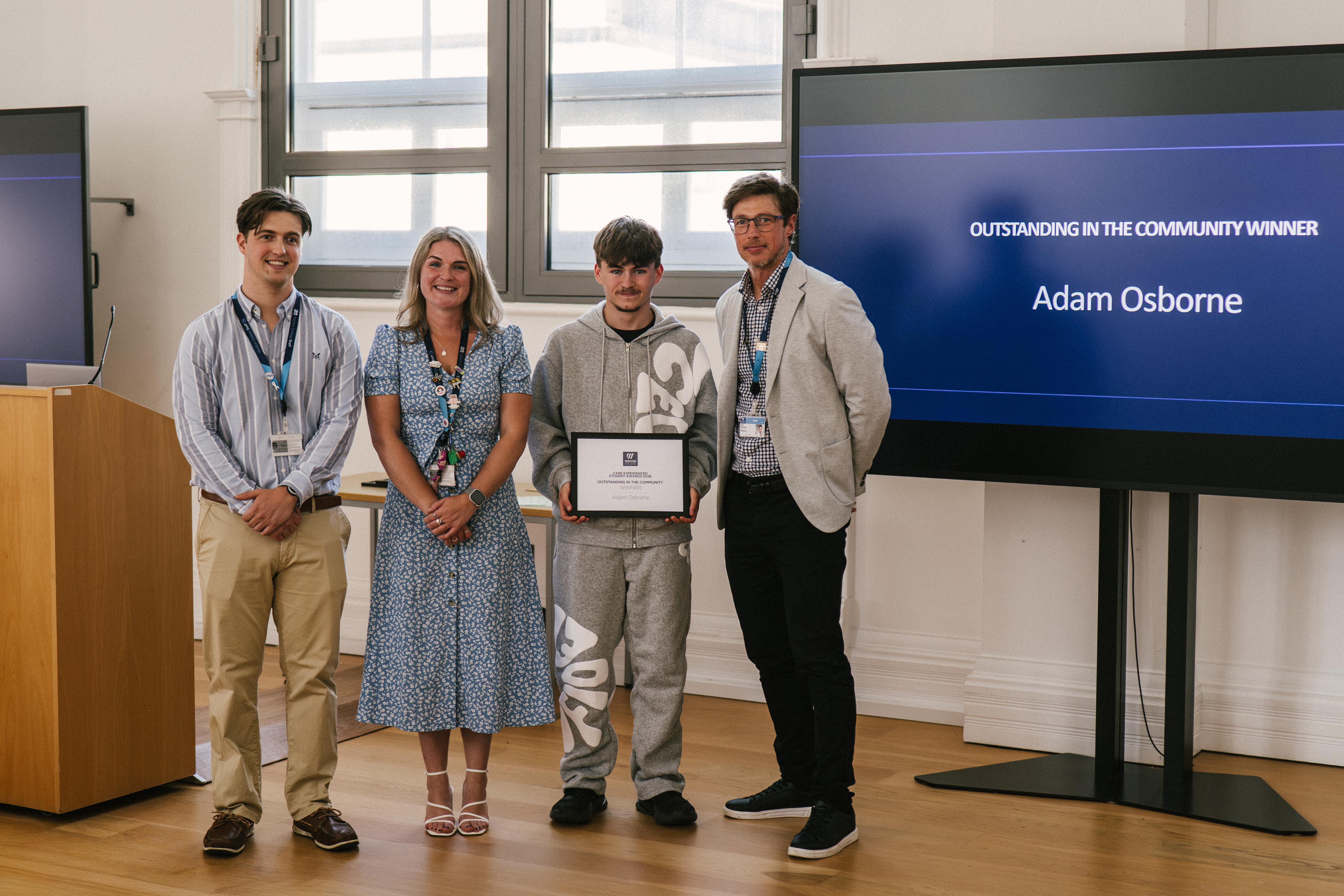 Student Holding Certificate with Staff