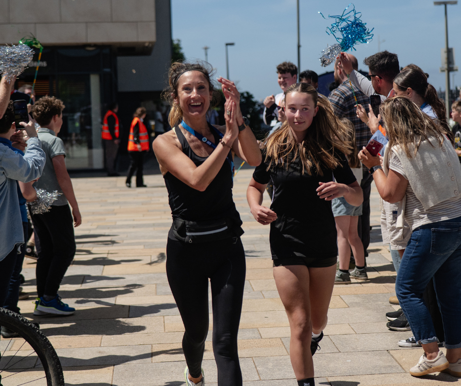staff and learners finishing their 16 mile run and being welcomed by other attendees