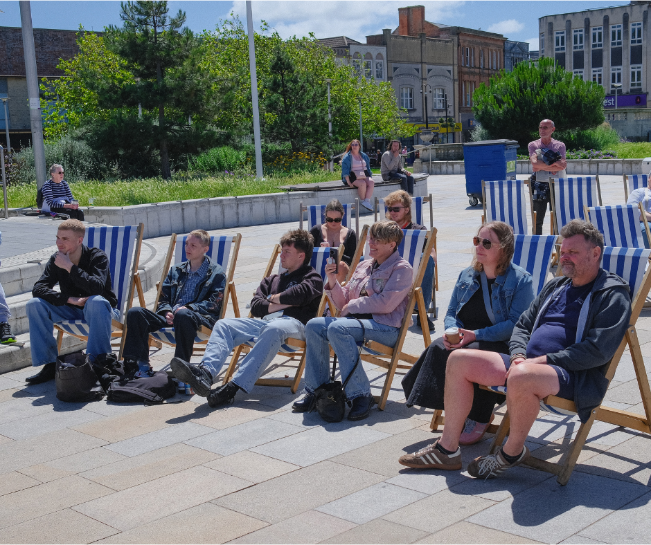 attendees listening to music whilst sitting on deck chairs