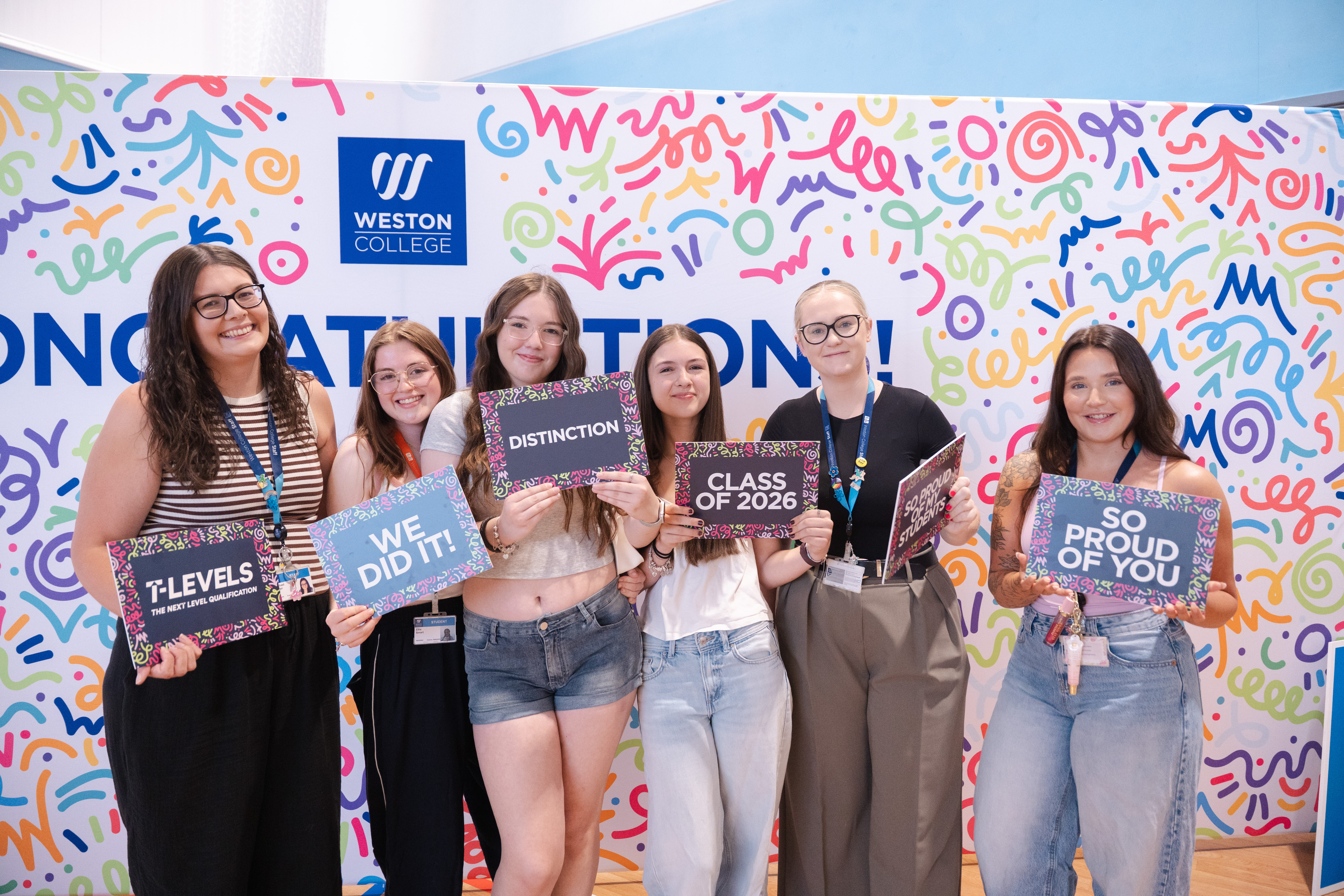 Learners and lecturers posing with photobooth props