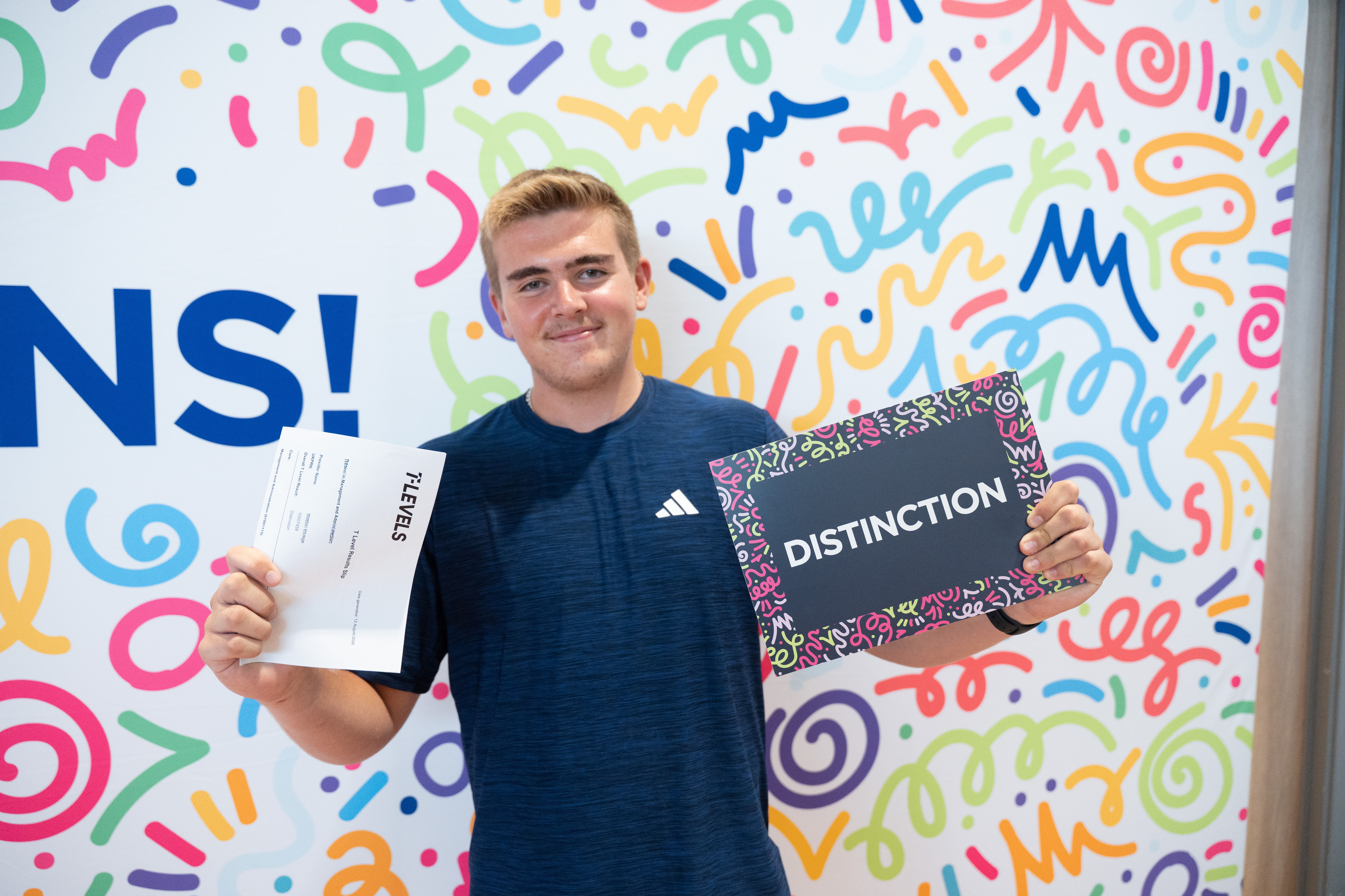 learner posing with results and photo prop