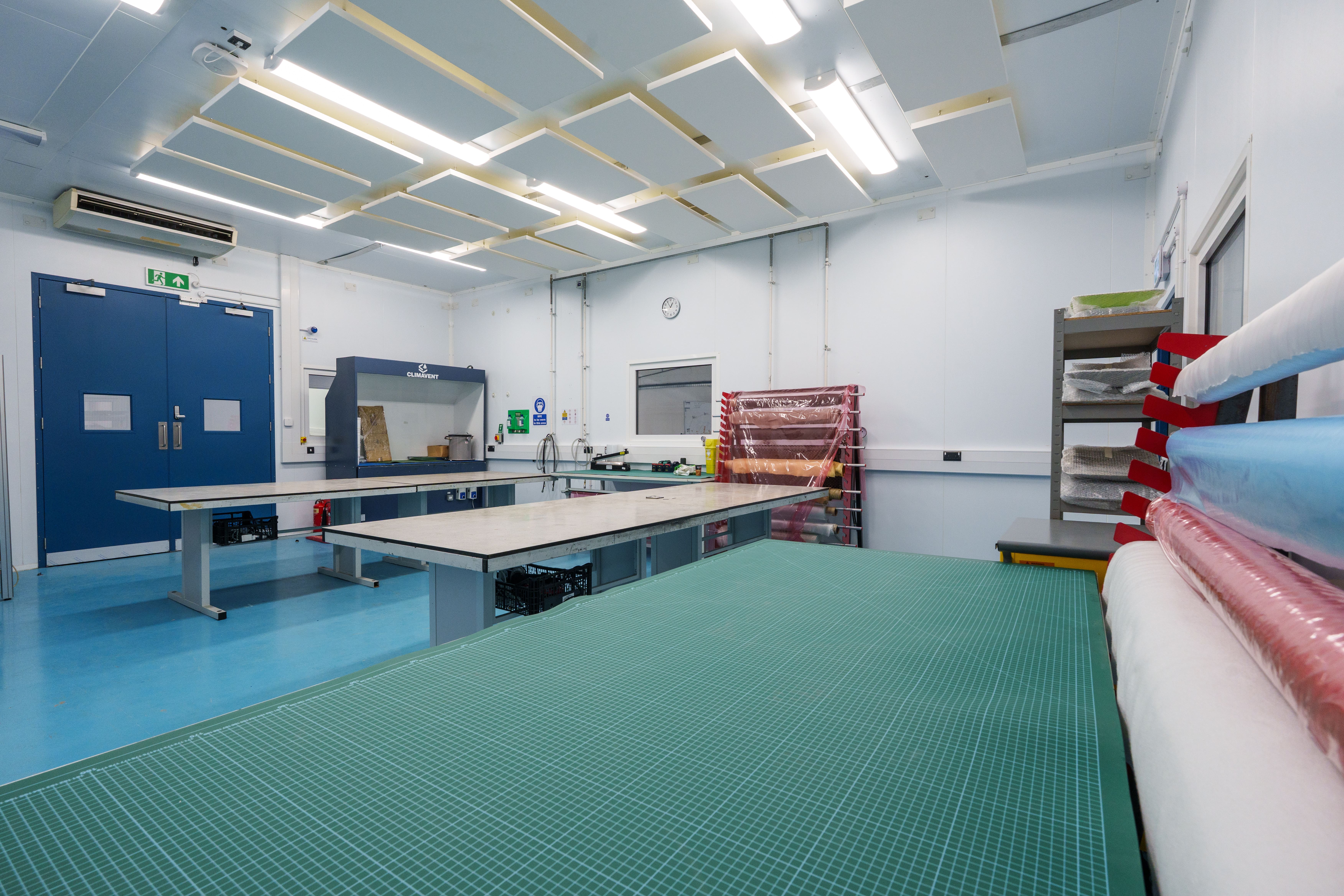 Specialist engineering workshop with large workbenches, materials and equipment.