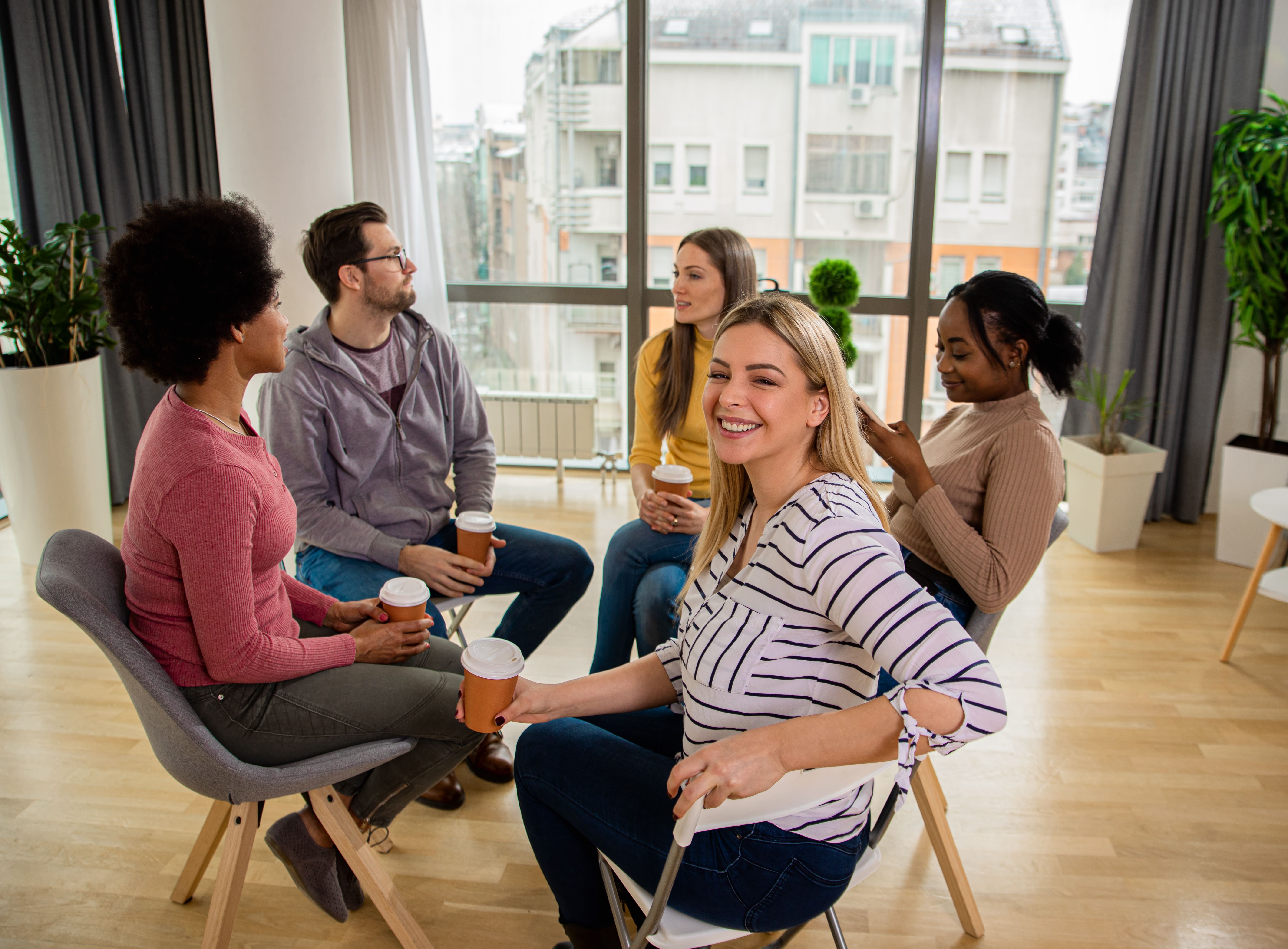 group of people looking at eachother and smiling and a women smiling at the camera