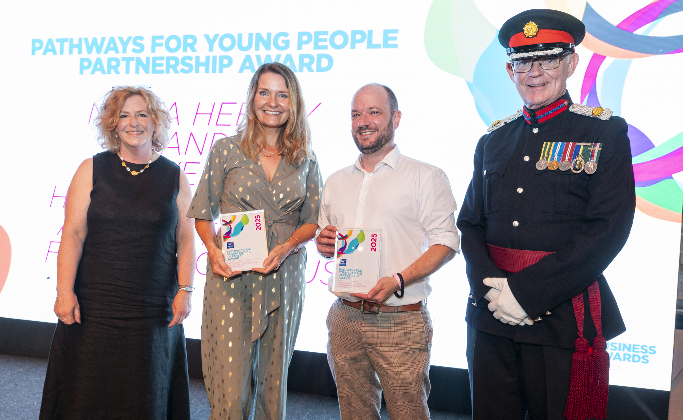 Nikita, standing on stage with her employer, and principle Pat Jones preseting the award and posing for a picture