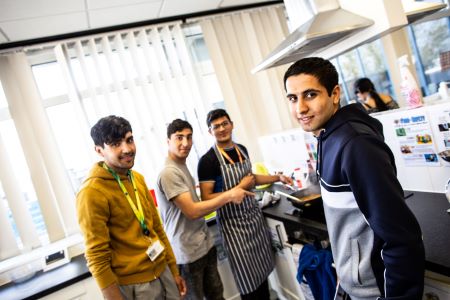 Group of learners smiling and pointing at their food creation