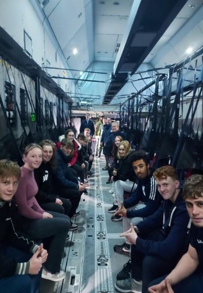 Learners sitting in plane and looking at camera