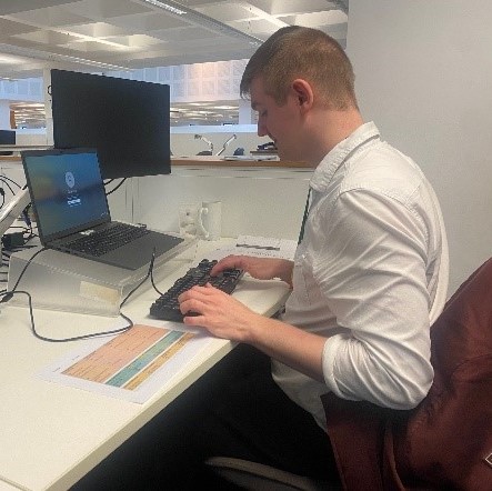 Dan typing on his computer at work