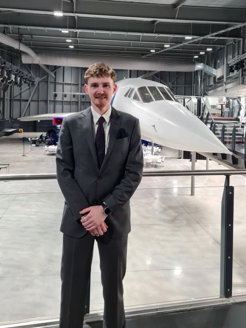 Bede next to airplane at airbus