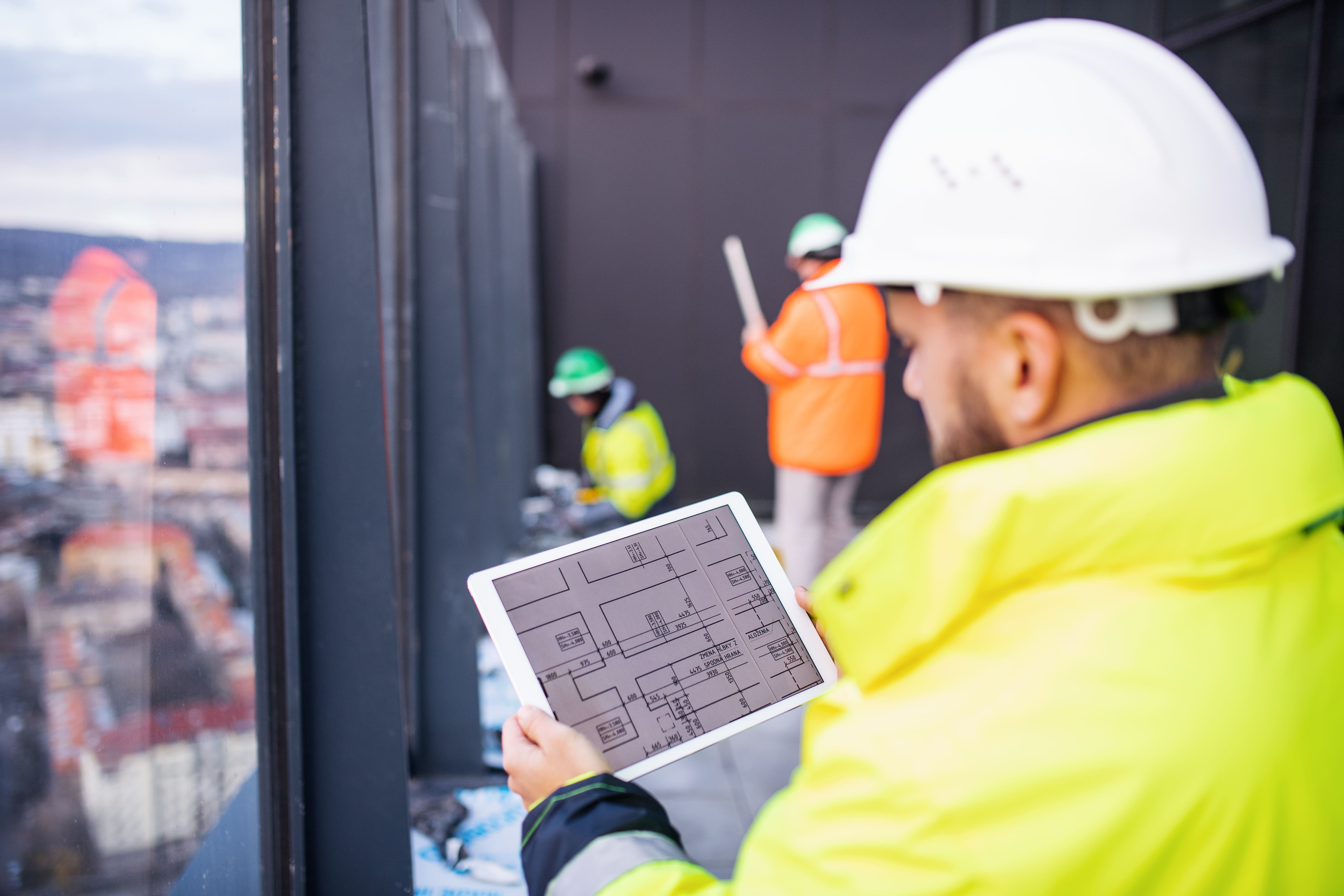 man construction manager looking at plans on tablet
