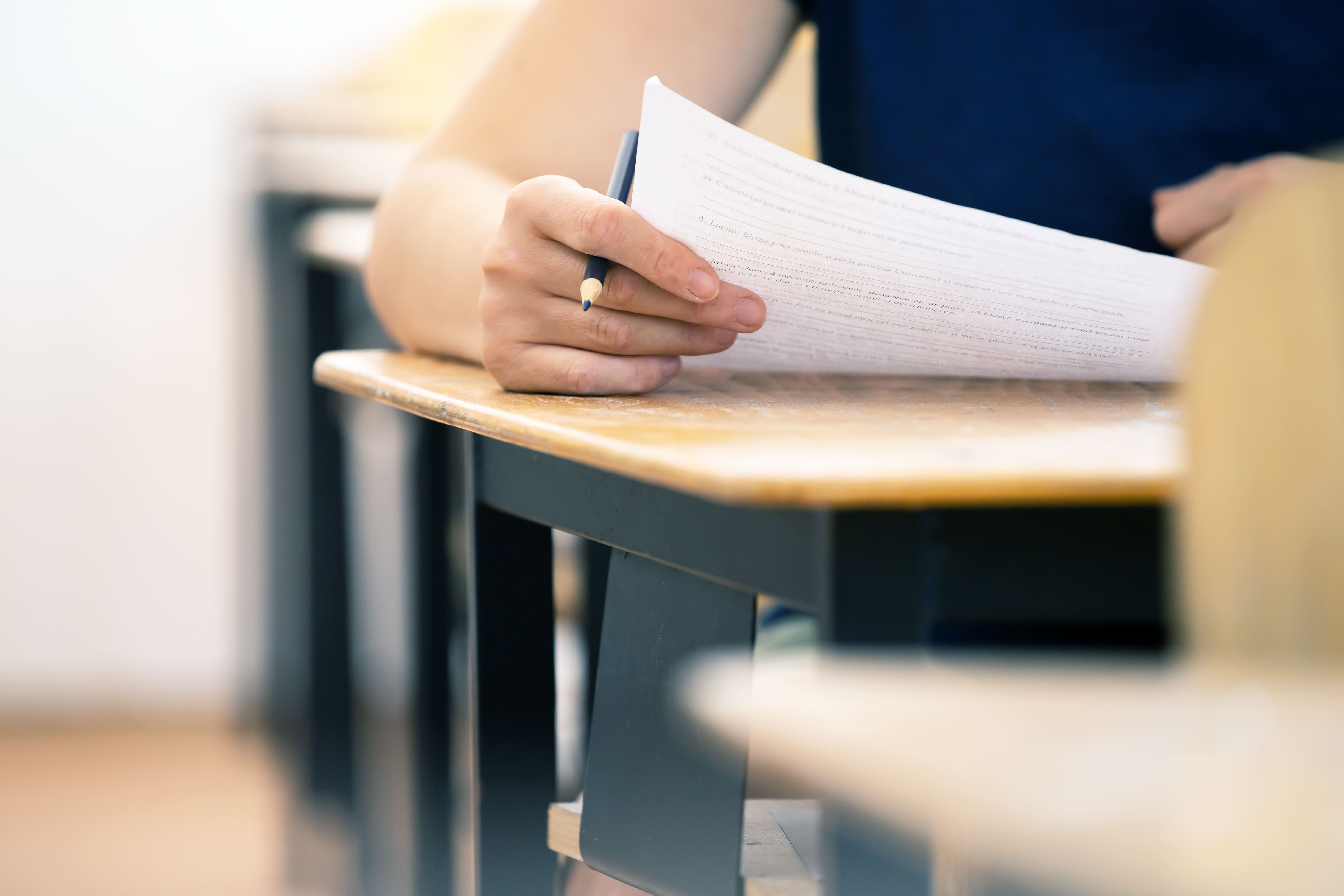 Student writing final exam in classroom