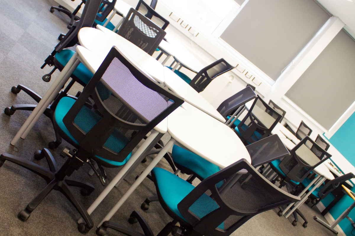 business classroom with circle tables with chairs around  