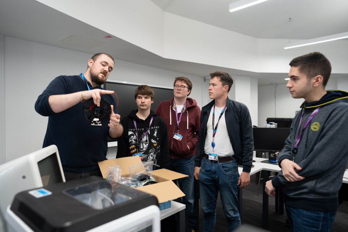 lecturer shows a PC fan to a group of students 
