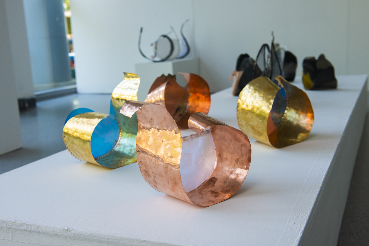 a group of different coloured mental ring sculptures sitting on top of a white table
