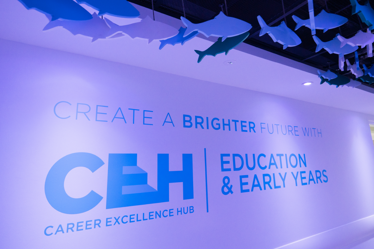 a wall with blue CEG logo, text and fish hanging from the ceiling