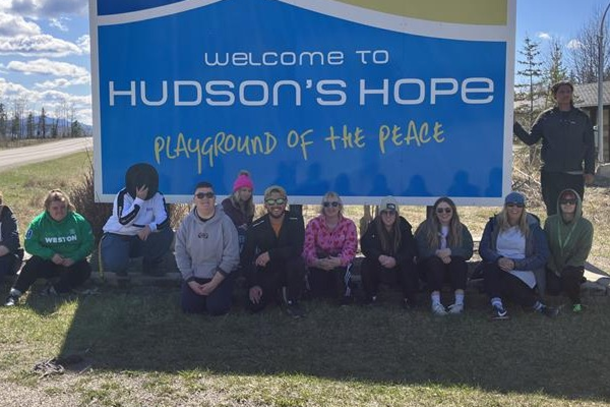 Students sat in front of the Hudson's Hope sign