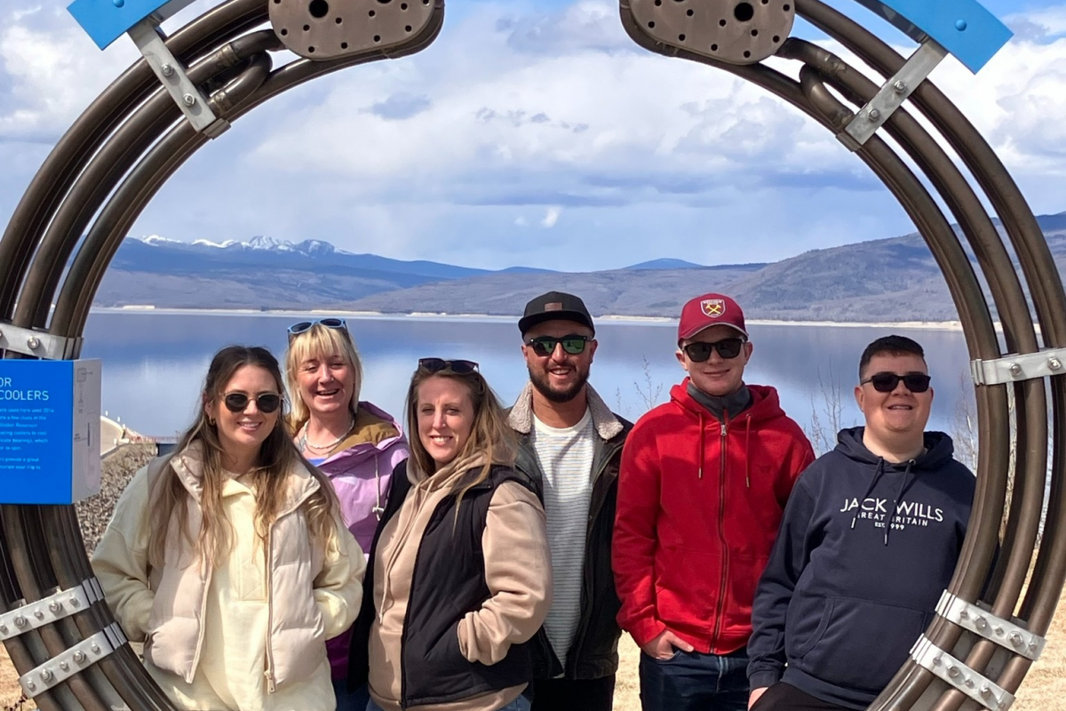 Students standing in front of the Bennett Dam sign 