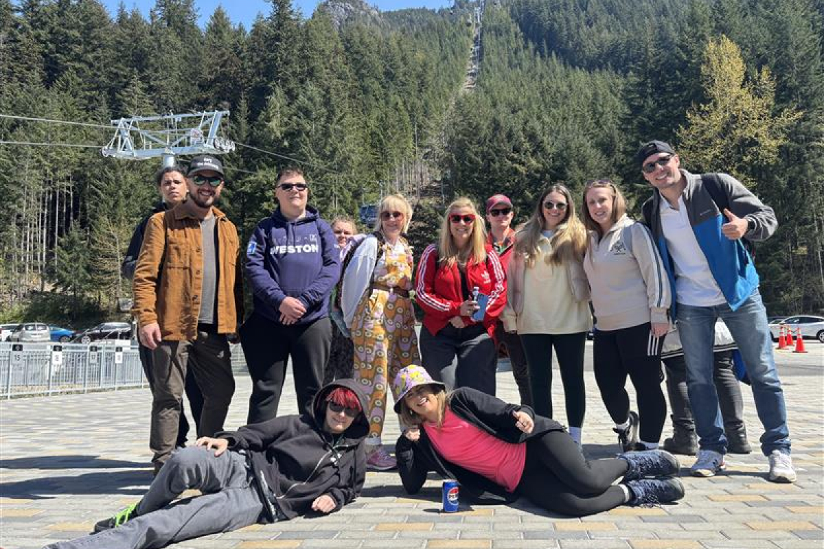 Students and staff standing in front of a mountain