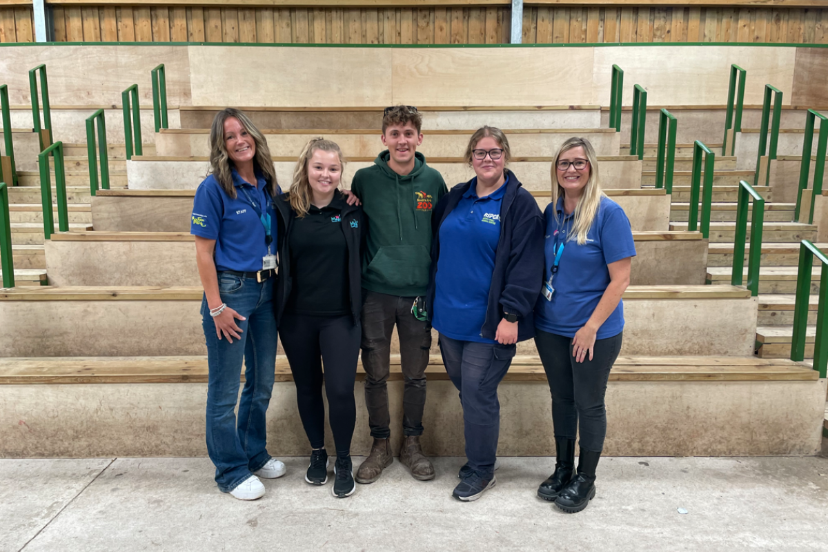 Former students and current lecturers standing together smiling 