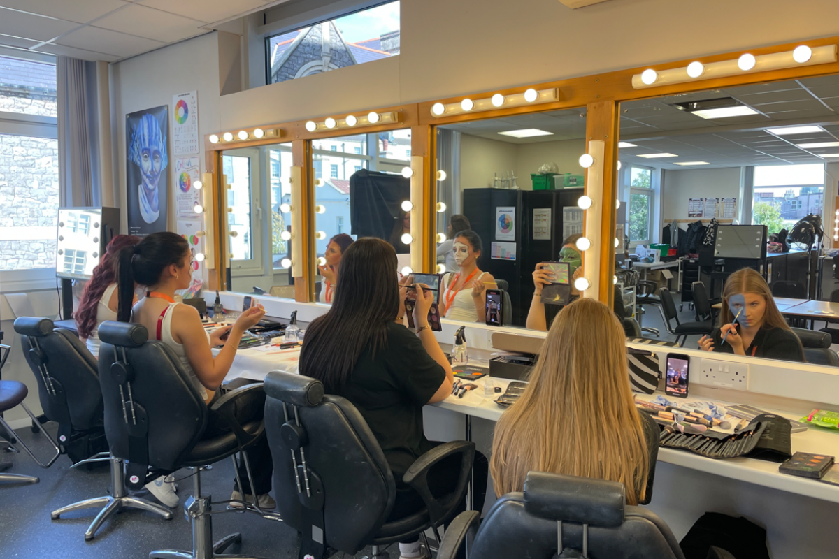 Media makeup students practicing creative face paint 